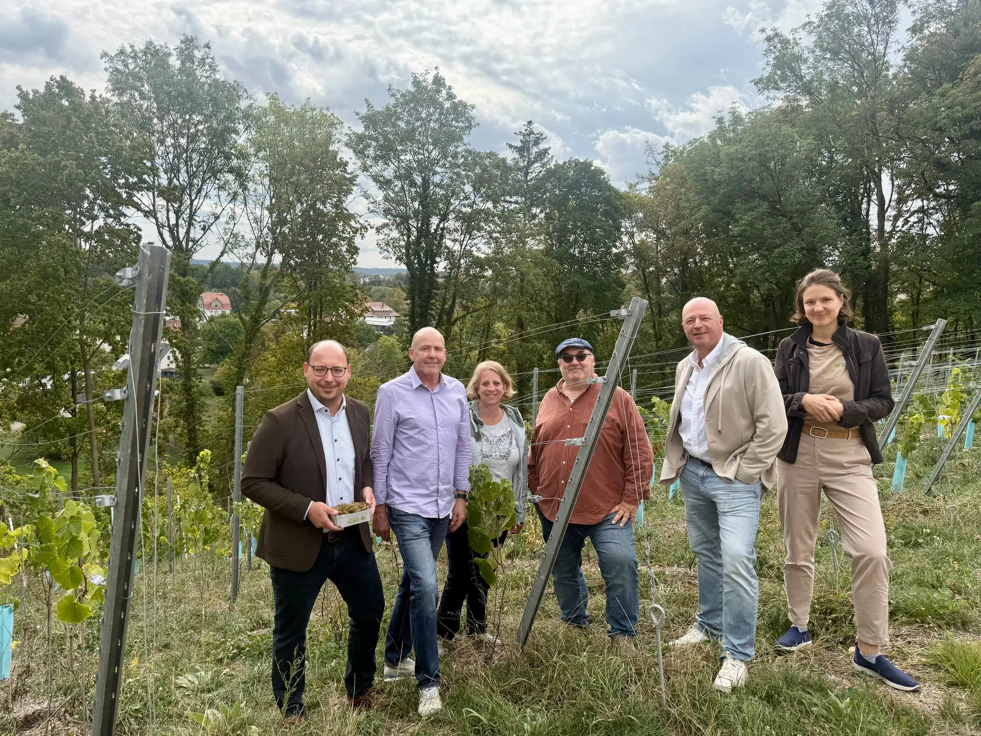 Oberbürgermeister Dr. Christian Ruf, die Vorstandsmitglieder Michael Schuler, Elke Hugger, Thomas Lippert und Michael Severin Grimm sowie Dr. Sarah Jotz beim Besuch des Bürgerweinbergs am Höllenstein.