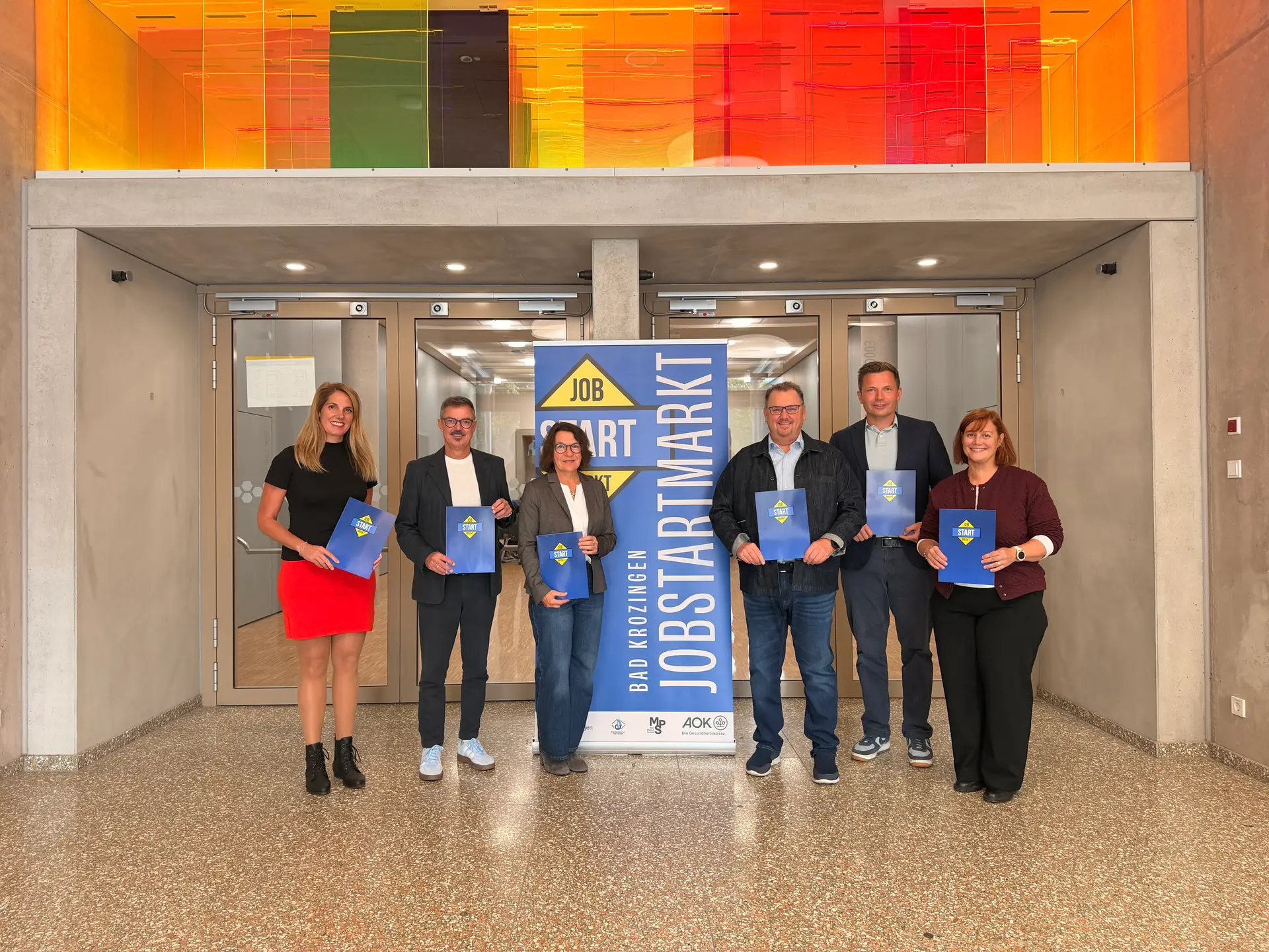 Gruppenfoto von mehreren Personen vor einem Gebäude.